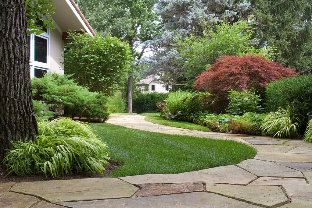Winding natural stone pathway in the backyard with mature landscaping in Lake Forest, IL | Milieu Landscaping