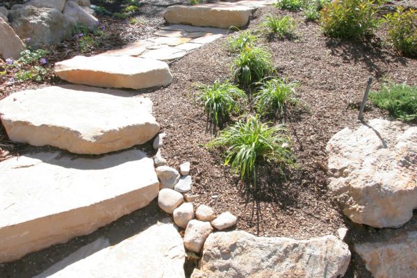 landscaping with accent stones, shrubs, and mulch