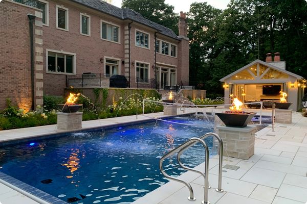 Beautiful swimming pool with hardscaping and fireplaces around