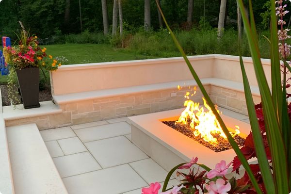 Stunning hardscape outdoor seating with fireplace and planting around