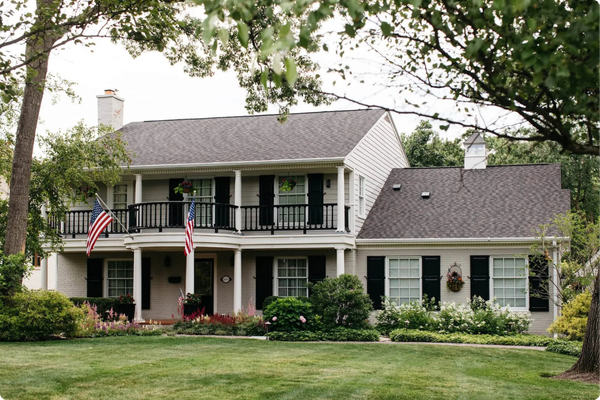 Image of a green lawn and shrubs in the background